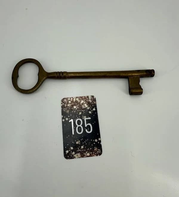 An Antique Brass Skeleton Key With An Ornate Bow.