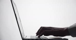 Silhouette of fingers touching laptop keyboard while typing text. Hands of a man uses a computer., Stock Footage